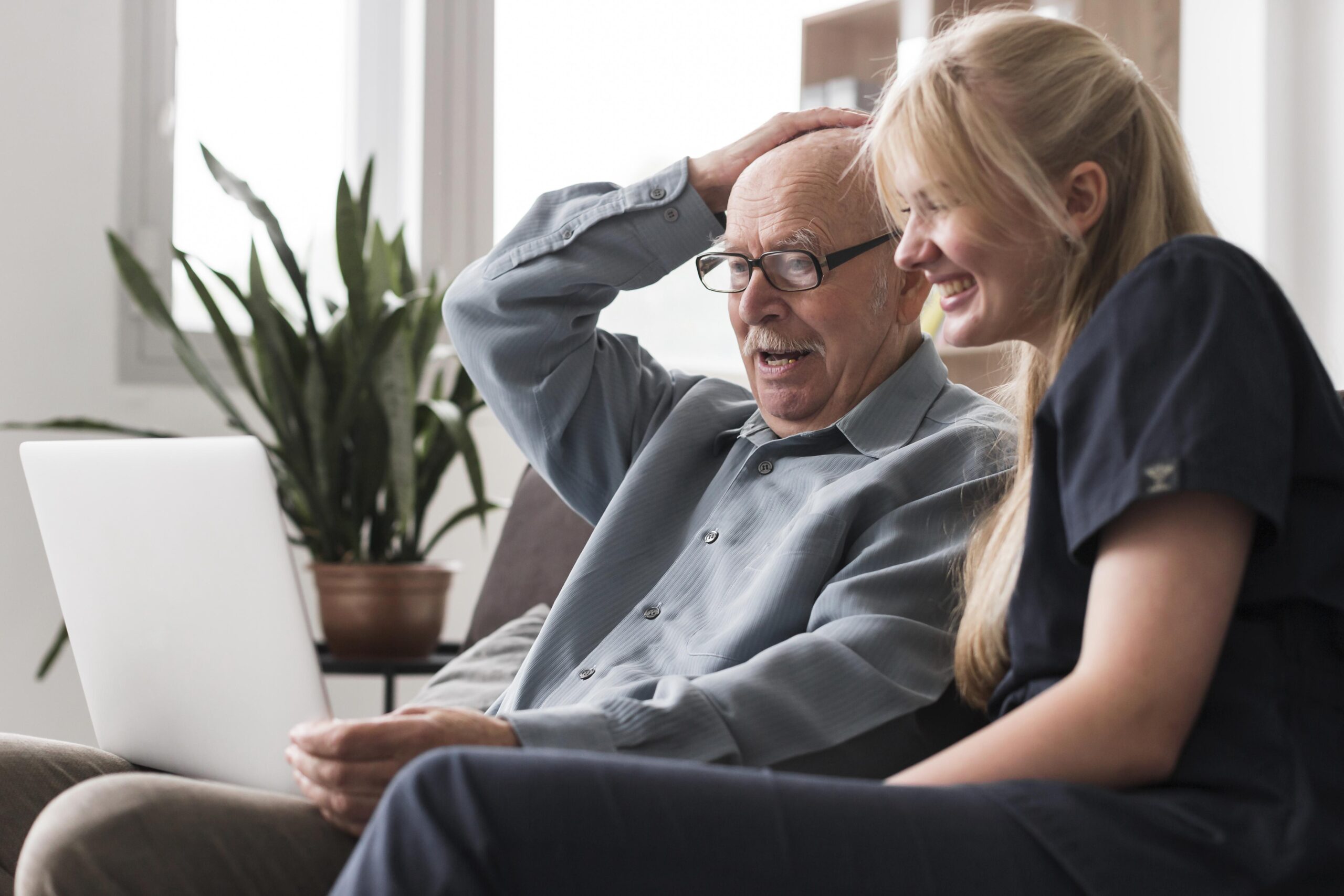 old-man-video-calling-family-from-nursing-home-with-nurse-s-help